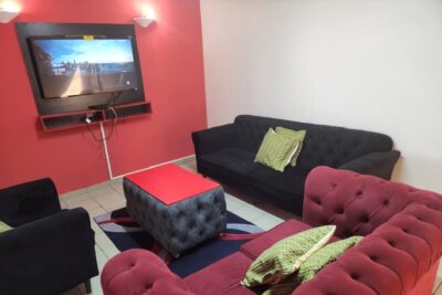 salon aménagé de 02-canapé, d'un fauteuil, d'une télévision, d'une table basse _appartement meublé à douala, bali