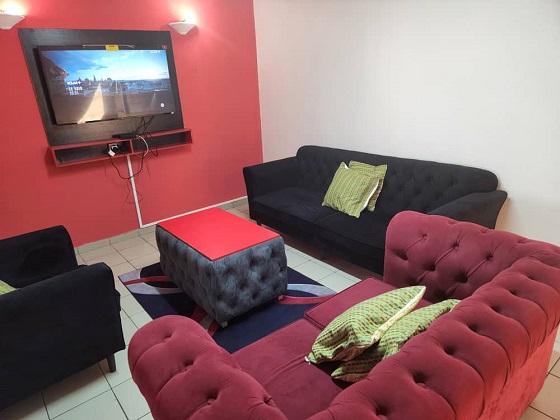 salon aménagé de 02 canapés, d'un fauteuil, d'une télévision, d'une table basse_ appartement meublé à douala bali